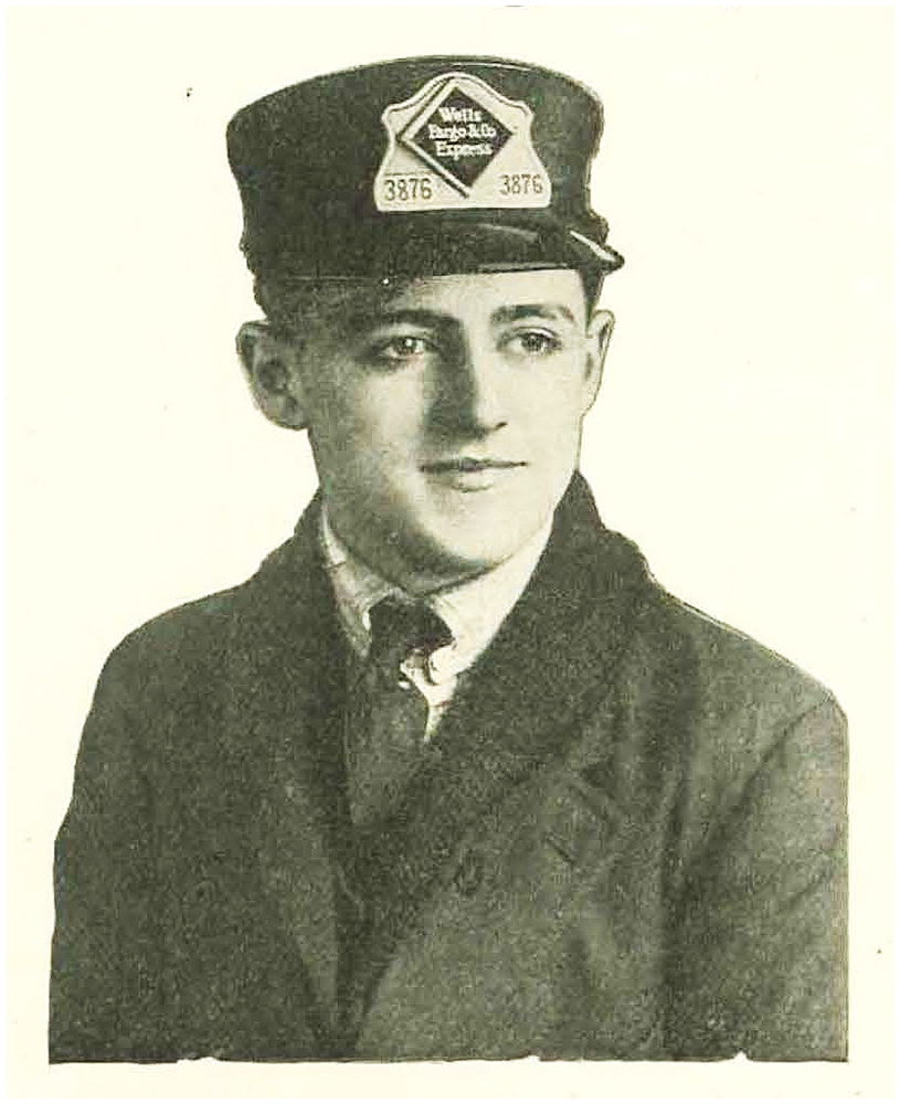 A young man in hat, jacket and tie, looking slightly left. A badge above his hat brim reads Wells Fargo & Co Express 3876.