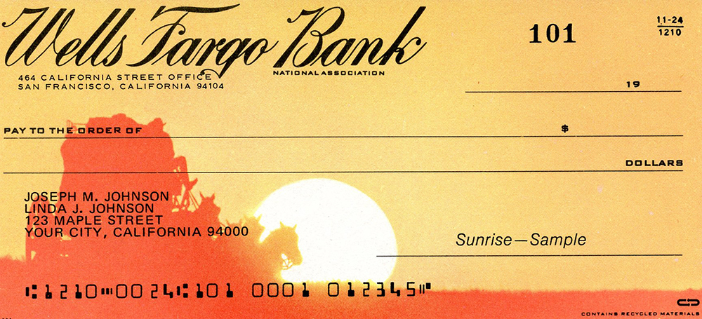 Printed Wells Fargo Bank check. Blank check shows stagecoach in silhouette against bright orange and yellow sunset background. Image is color.