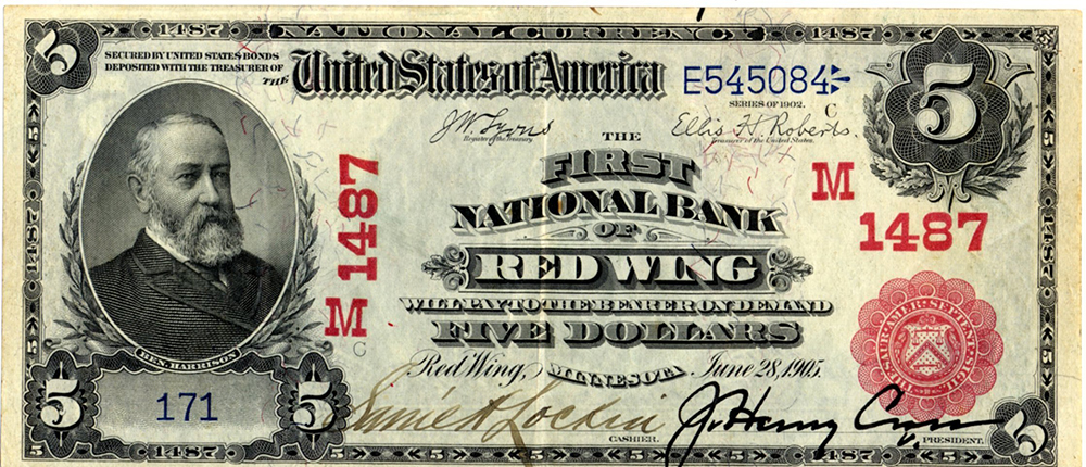 Five dollar bill of U.S. currency printed with name of First National Bank of Red Wing, center. Portrait of Harrison on left, numeral five on corners. Two signatures of cashier and president of bank at bottom. Additional treasury seal and bank charter number overprinted in red.