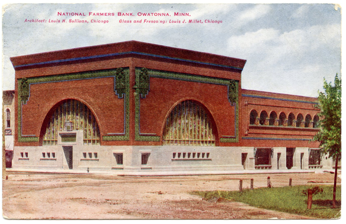 Color postcard of red brick bank building on corner. Includes large decorative arched windows and terra cotta green tile trim. Small type at the top identifies Louis Sullivan as the architect.