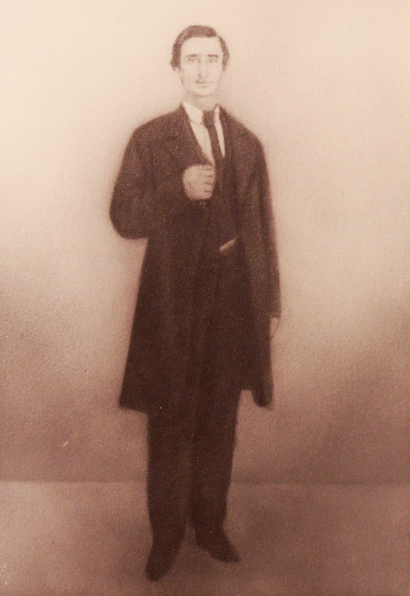 Full-length drawing of young man with dark hair. He stands against a plain light background, looking right with right hand clutching lapel of dark colored suit.