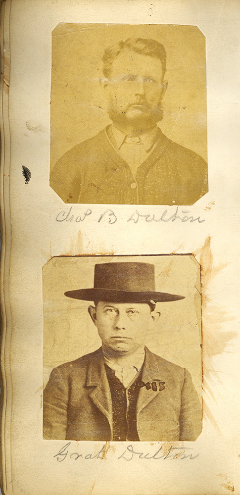 Head and shoulders photos of two men looking directly at camera, mounted on a vertical book page. Man in upper photo, with beard, identified in pencil handwriting as Chas (Charles) B. Dalton. Man in lower photo, wearing brimmed hat, identified as Grat Dalton.