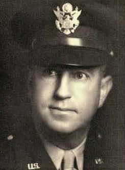 Head and shoulder portrait of man in WW II military officer’s hat and uniform, looking right.
