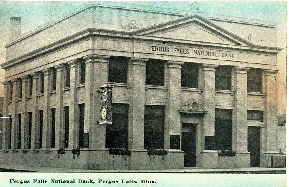 Color postcard of the Fergus Falls National Bank building in Minnesota. The building is square shaped with doric columns. A clock hangs on the corner.