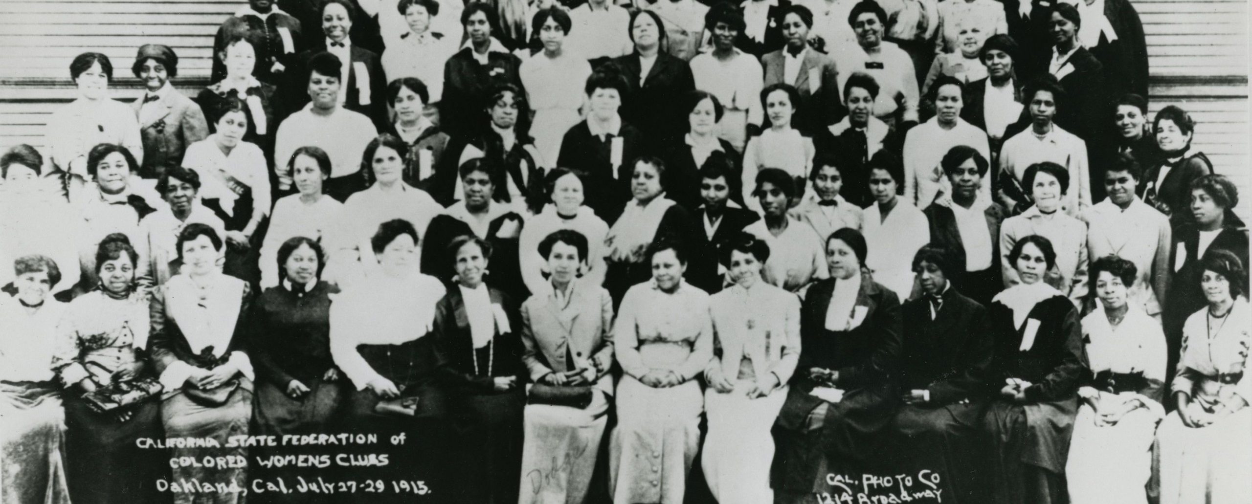 Group portrait taken on stairs outside of building of the California State Federation of Colored Women’s Club dated 1915. Five rows of women, both seated and standing are crowded into the picture.