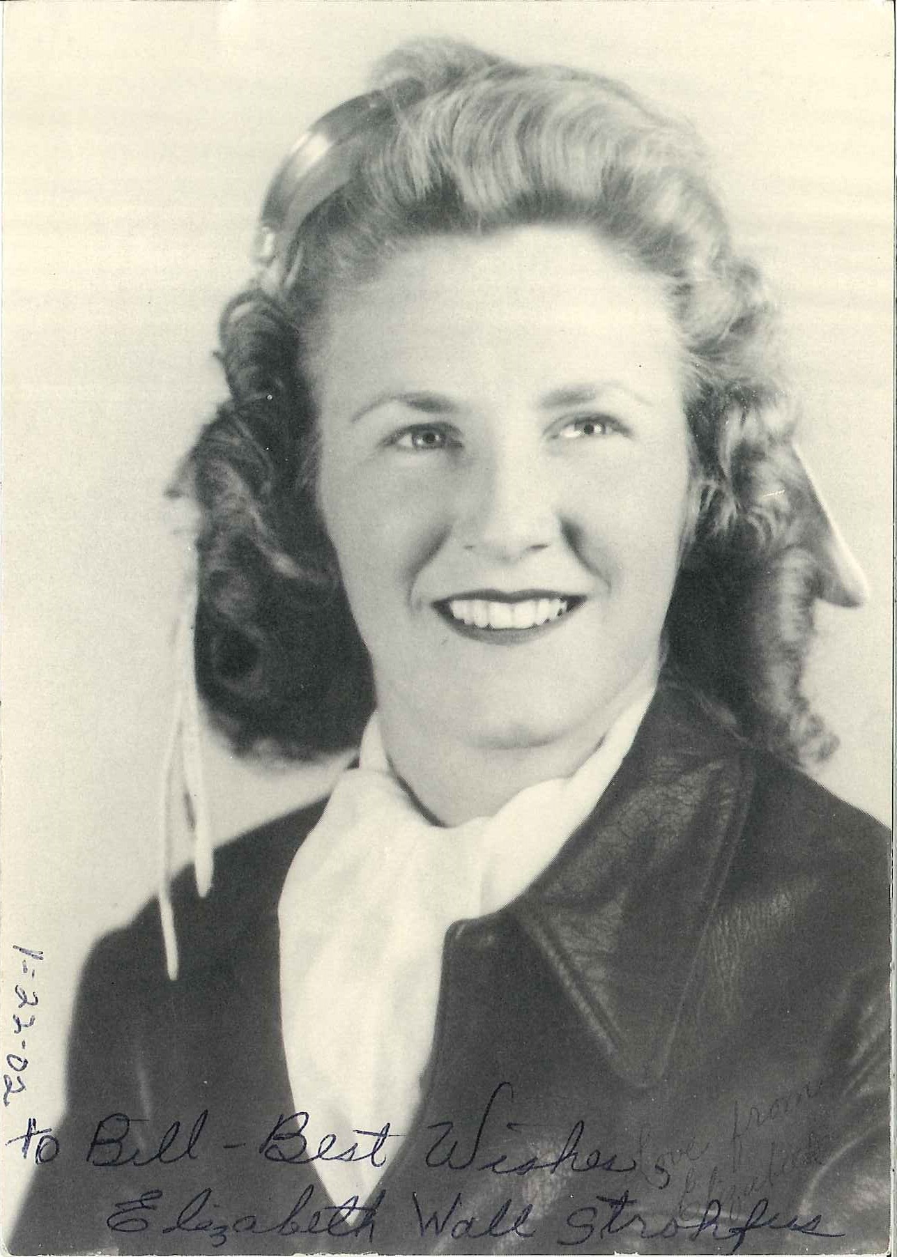 Elizabeth “Betty” Wall in her leather flight jacket. Historic black and white photograph taken in 1940s. Signed TO Bill Best Wishes Elizabeth Wall Strohfus.