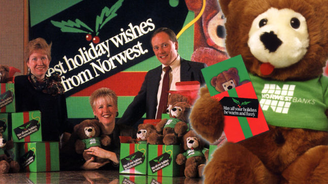 On the right a brown plush bear wearing a green shirt with the white Norwest logo holds an offer brochure bearing his same image above a red gift box. Behind the bear are three people, two are standing and one is sitting at a table full of gift boxes in green with red bows. Plush Buddy bears are in the gift boxes and a sign on the wall reads best holiday wishes from Norwest.