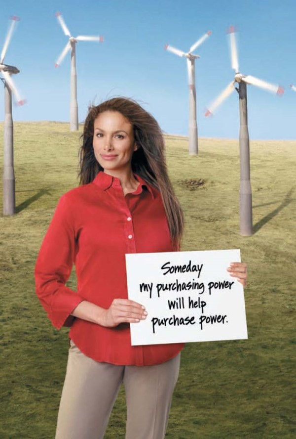 On left, woman standing in front of windmills in open field with blue sky, holding sign with text “Someday my purchasing will help purchase power.”