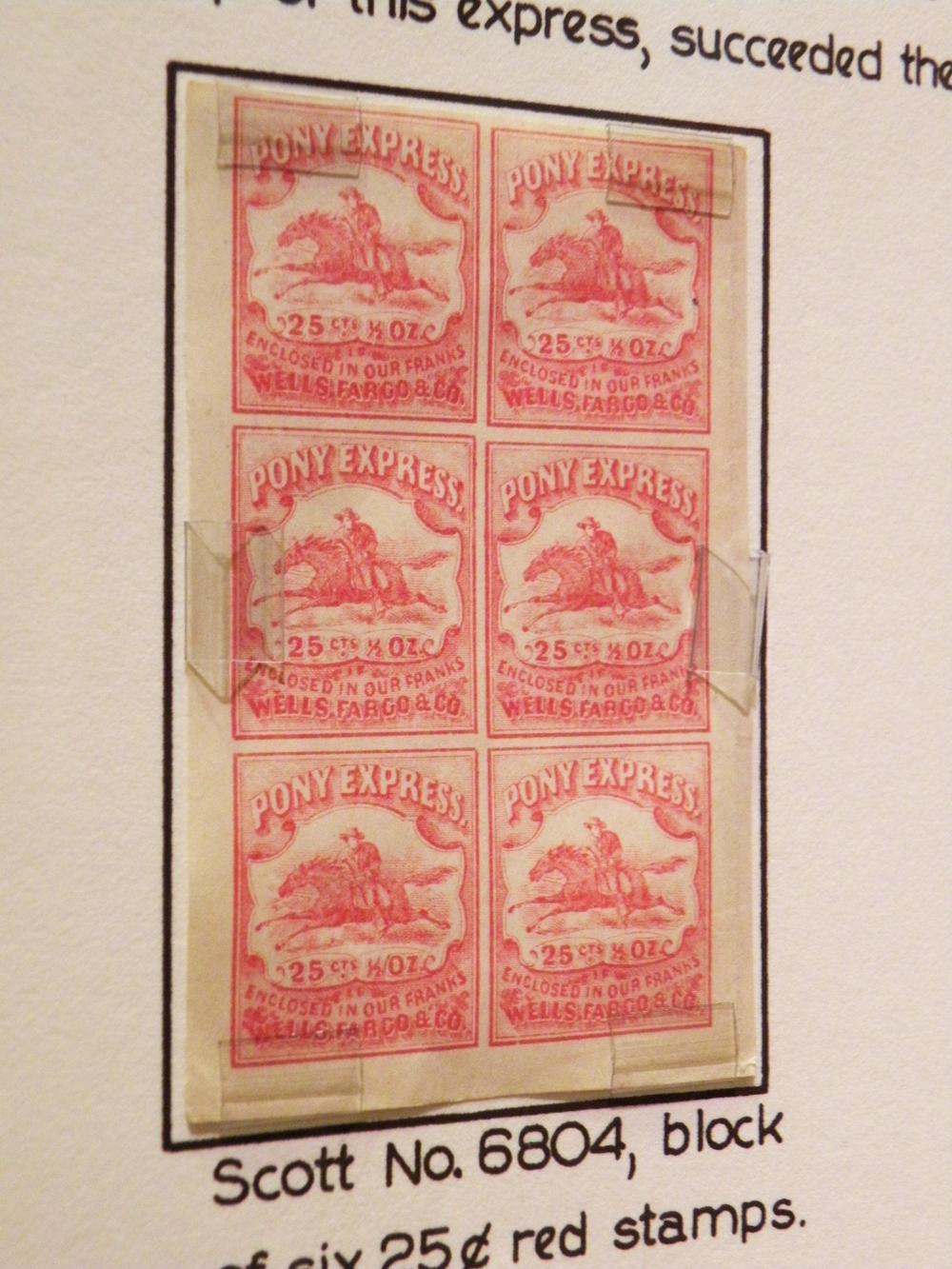 An exhibit panel with six red Pony Express stamps showcased. Below the panel it reads: Scott No. 6604, block 25¢. Image link enlarges image.