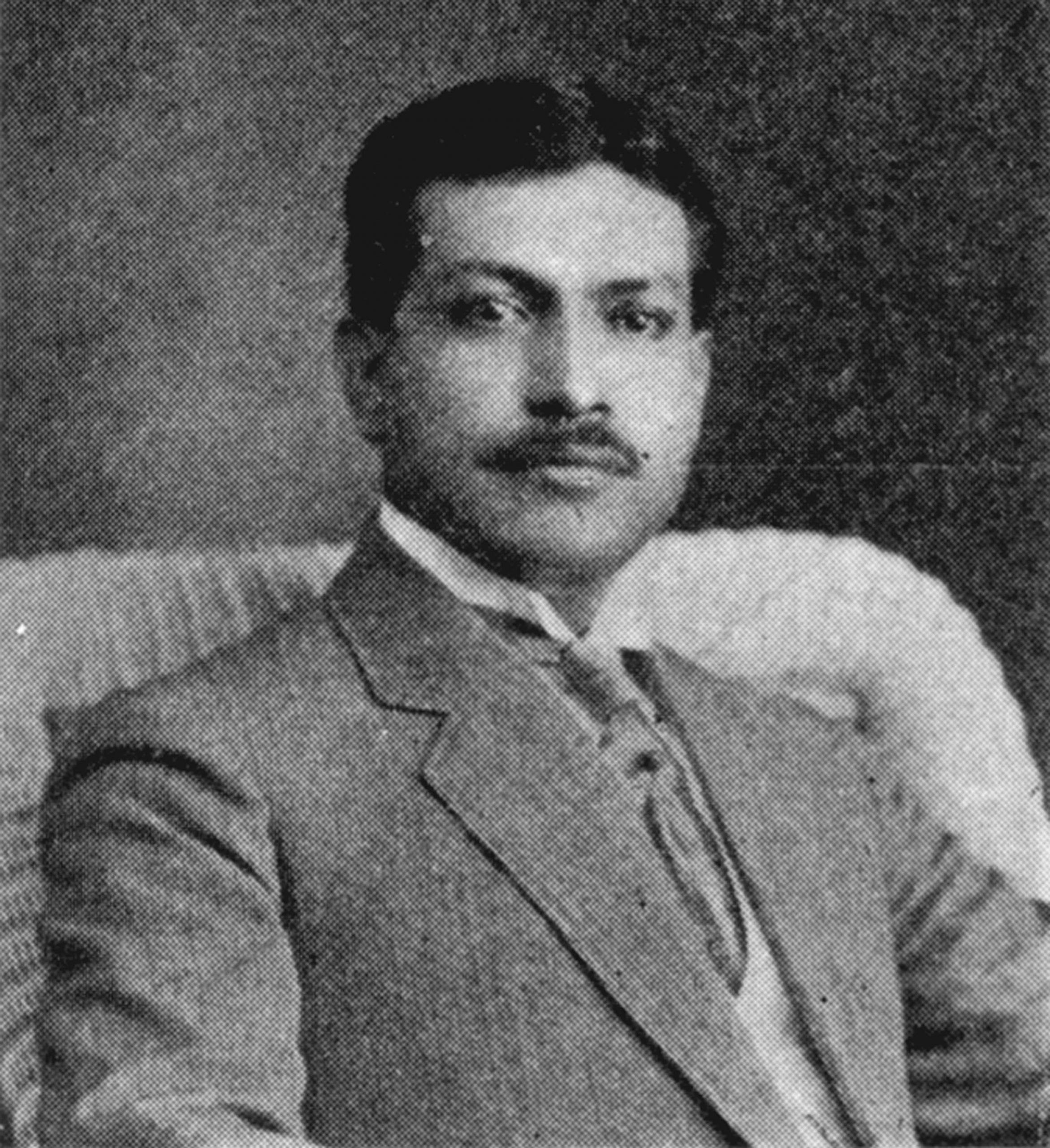 A black-and-white photo shows J. C. Ybarra in a suit sitting in a chair. He has dark hair and a mustache. Image link will enlarge image.